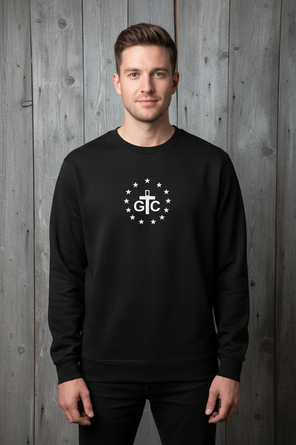 Male model wearing black G&C crewneck with relaxed fit against rustic wood